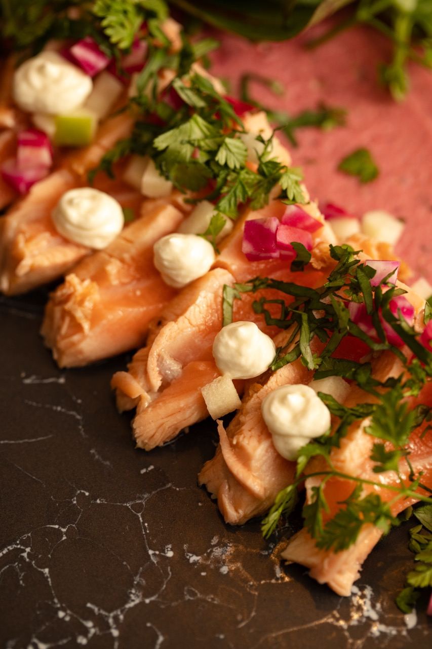 Tataki de saumon, crème et herbes, en gros plan